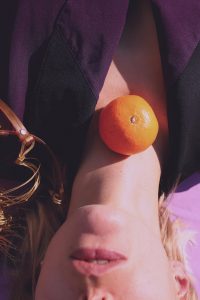 orange fruit on woman s neck